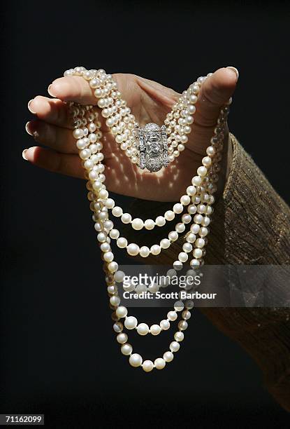 Jewellery specialist from Christie's holds an Art Deco Pearl and Diamond Necklace during a photocall of jewellery and works of art from the...
