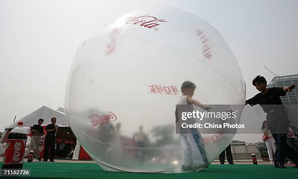 Boy plays in a giant ball on June 9, 2006 in Nanjing of Jiangsu Province, China. Billboards and decorations featuring the World Cup, which starts...