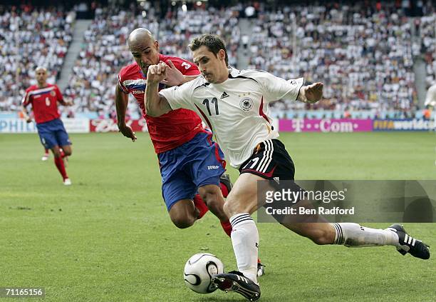 Miroslav Klose of Germany is challenged by Douglas Sequeira of Costa Rica during the FIFA World Cup Germany 2006 Group A match between Germany and...