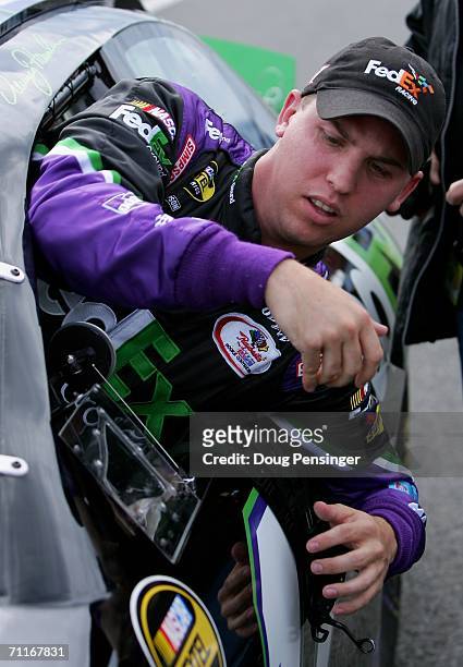Denny Hamlin, driver of the FedEx Ground Chevrolet, climbs out of his car as he won the poll during qualifying for the NASCAR Nextel Cup Series...