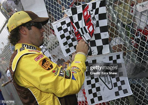 Elliott Sadler, driver of the Mega M&M's Ford, signs autographs during qualifying for the NASCAR Nextel Cup Series Pocono 500 on June 9, 2006 at the...