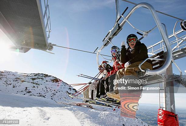 Skiers and snowboarders gesture from a ski lift as they take to the slopes at Mt Hutt on the first day of the ski season June 10, 2006 in Methvan,...