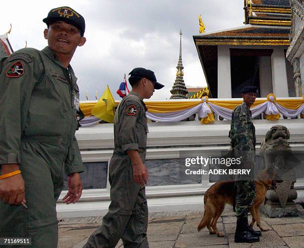 Security guards check around the Grand Palace prior to a Buddist ceremony, as part of the ongoing celebrations for the 60th anniversary of king...