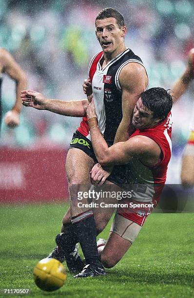 Brett Voss of the Saints is tackled by Adam Schneider of the Swans during the round 11 AFL match between the Sydney Swans and the St Kilda Saints at...