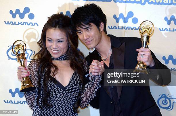 Taiwanese singer Leehom Wang and Singapore's singer Tanya Chua display their trophies after winning the Best Male and Female Mandarin Singer...