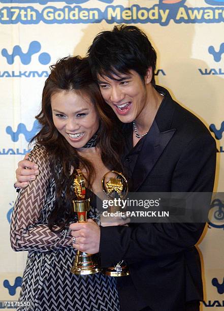 Taiwanese singer Leehom Wang and Singapore's singer Tanya Chua display their trophies after winning the Best Male and Female Mandarin Singer...