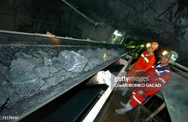 Philex mining engineers Venancio Gel Romero and Joel Son checks crushed ore transported in a converyor belt from the tunnel 700 meters under Mount...