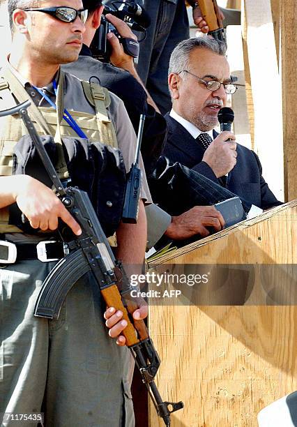 Armed security personnel guard Iraqi Vice President Tariq al-Hashmi as he speaks to Iraqi prisoners before their release 11 June 2006 at Abu Ghraib...