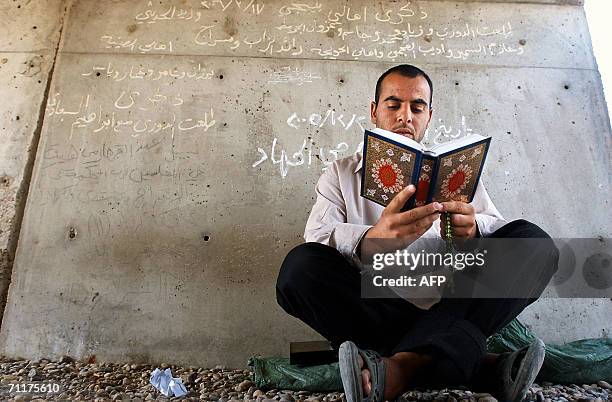 An Iraqi prisoner reads from the holy Koran before his release 11 June 2006 at Abu Ghraib prison west of Baghdad. Iraq released 230 detainees today,...