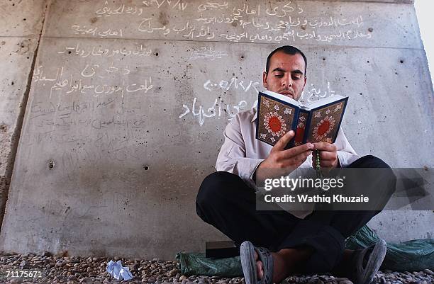 An Iraqi prisoner reads holy Quran before his release from Abu Ghraib prison, on June 11, 2006 west of Baghdad, Iraq. More than one hundred Iraqi...