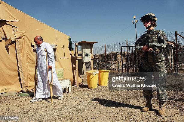 Soldier stands guard near a handicapped Iraqi prisoner waiting to be released from Abu Ghraib prison, on June 11, 2006 west of Baghdad, Iraq. More...
