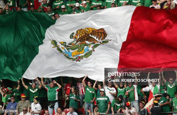 Fans hold up a giant Mexican flag at Nuremberg's Franken Stadium ahead of the first round Group D World Cup football match between Mexico and Iran,...