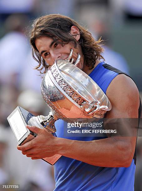 Spain's Rafael Nadal celebrates with the trophy after defeating Swiss Roger Federer during the French tennis Open finals at Roland Garros in Paris 11...