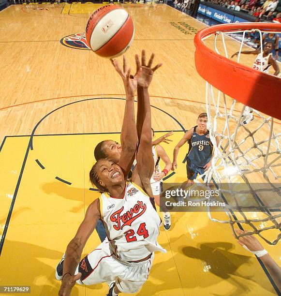 Tamika Catchings of the Indiana Fever battles a Seattle Storm defender on June 11, 2006 at Conseco Fieldhouse in Indianapolis, Indiana. The Fever...