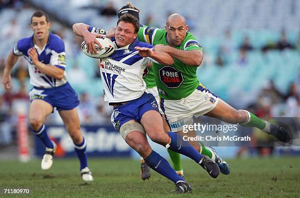 Corey Hughes of the Bulldogs is tackled by Jason Croker of the Raiders during the round 14 NRL match between the Bulldogs and the Canberra Raiders...