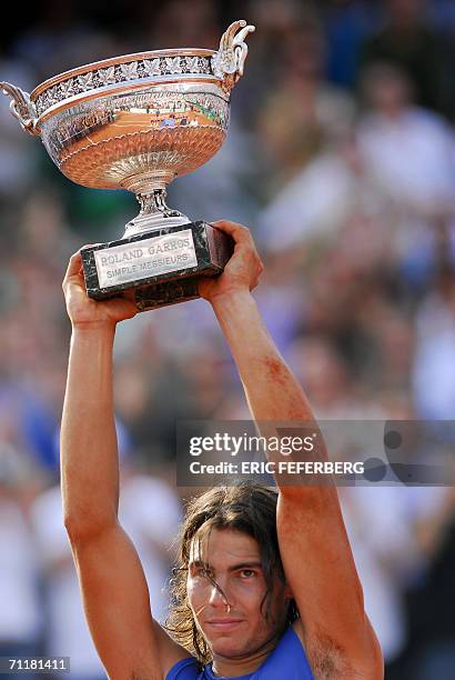 Spain's Rafael Nadal holds the trophy after defeating Swiss Roger Federer during the French tennis Open finals at Roland Garros in Paris 11 June...