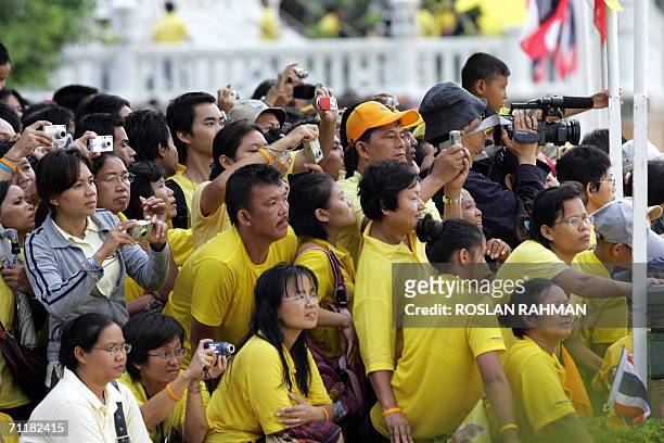 People with cameras and videos line-up along the Chao Phraya river to witness the procession of the royal barges in a celebration to mark the 60th...