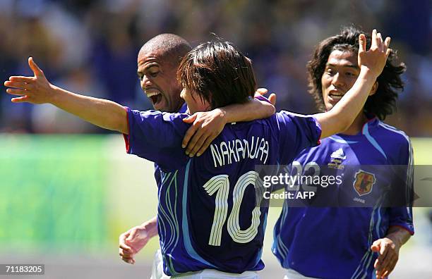 Kaiserslautern, GERMANY: Japanese midfielder Shunsuke Nakamura is congratulated by teammates Japanese defender Alessandro Santos and Japanese...