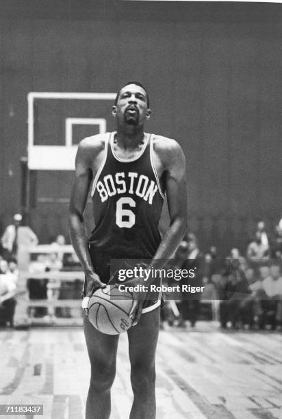 American basketball player Bill Russell of the Boston Celtics breathes deeply as h lines up a free throw during a game, late 1950s or 1960s.