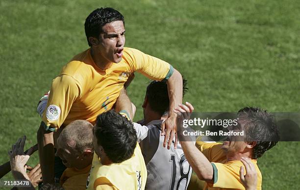 Tim Cahill of Australia is held aloft by after scoring his team's second goal during the FIFA World Cup Germany 2006 Group F match between Australia...