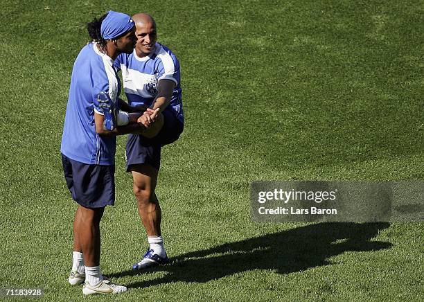 Ronaldinho stretches with team mate Roberto Carlos during a Brazil National Football Team training session at the Berlin Worldcupstadium on June 12,...