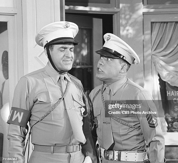 American actor Jim Nabors grimaces as fellow actor Frank Sutton trembles with anger in an episode of the television comedy series 'Gomer Pyle, USMC'...