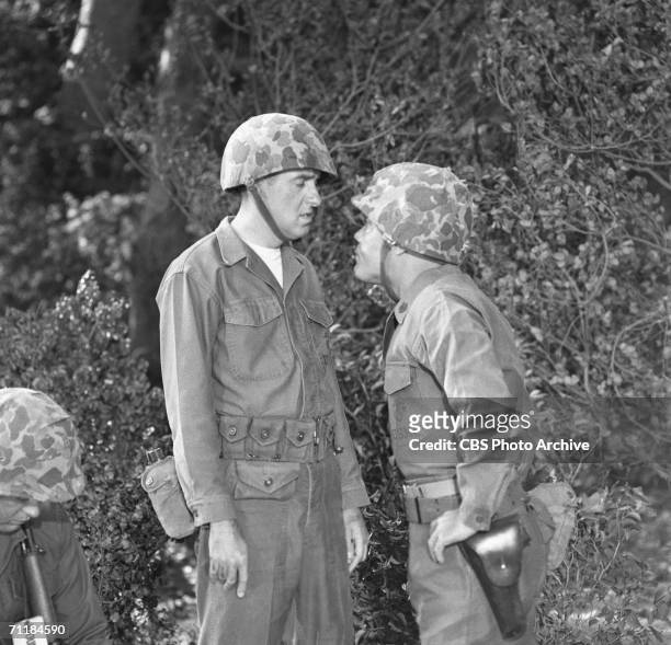 American actor Frank Sutton leans in close to fellow actor Jim Naborsin a scene from an episode of the television comedy series 'Gomer Pyle, USMC'...
