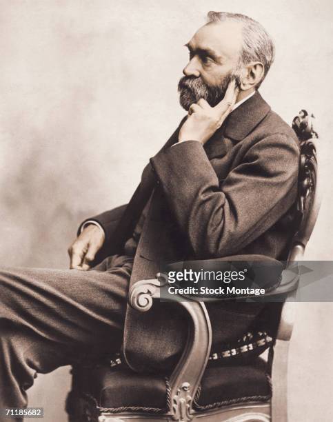 Colorized profile portrait shows Swedish inventor and philanthropist Alfred Nobel 1833 - 1896) as he sits in a chair, 1800s. Nobel established the...