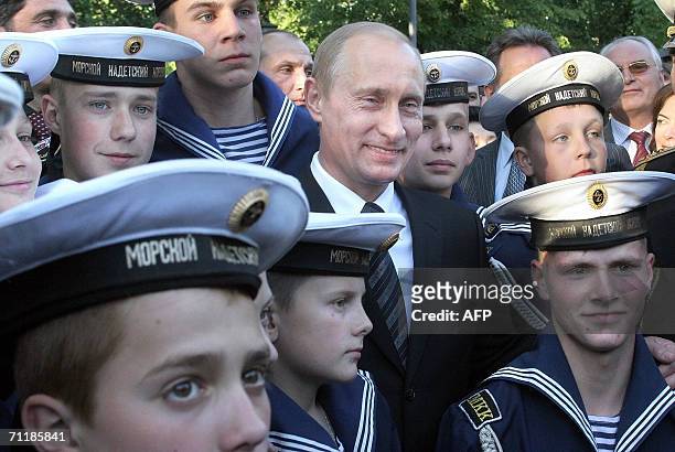 St Petersburg, RUSSIAN FEDERATION: Russian President Vladimir Putin smiles as he and navy cadets pose during the opening of a monument honoring the...