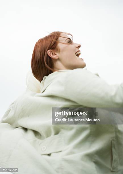 woman's jacket blowing in the wind - überzieher stock-fotos und bilder