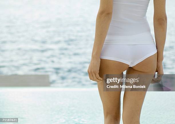 woman standing by edge of water, rear view of mid-section - beach bum imagens e fotografias de stock