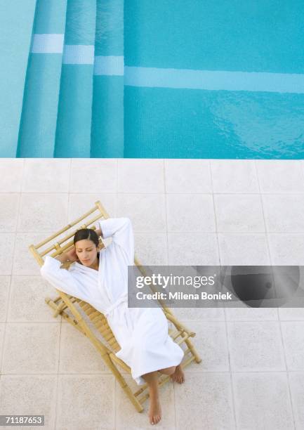 woman lounging in chair by pool, high angle view - robe stock pictures, royalty-free photos & images