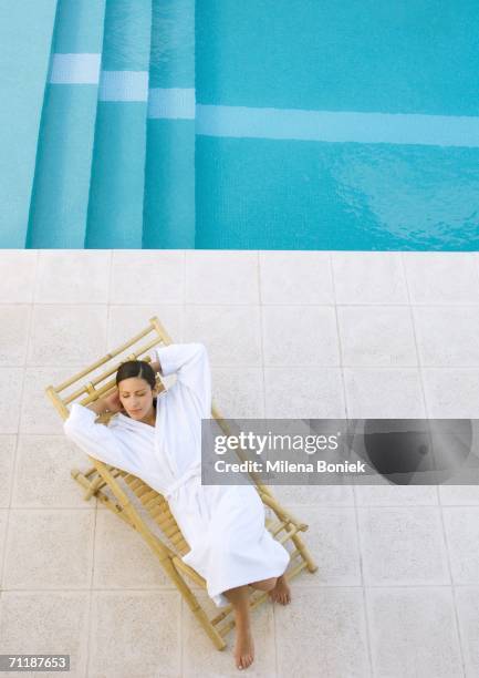 woman lounging in chair by pool, high angle view - robe stock pictures, royalty-free photos & images