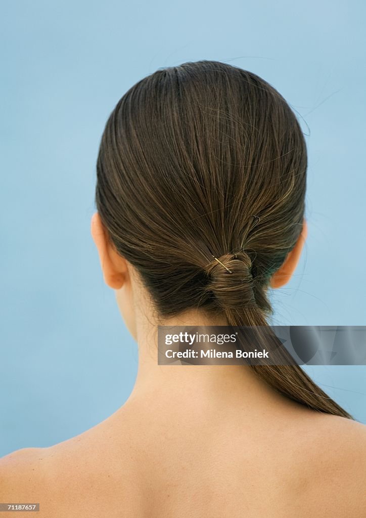 Woman's bare upper back and head with ponytail