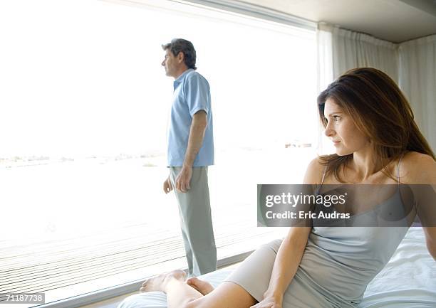 mature couple, apart in bedroom - midlife crisis stock pictures, royalty-free photos & images