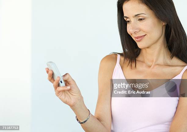 woman looking at cell phone - feature phone stockfoto's en -beelden