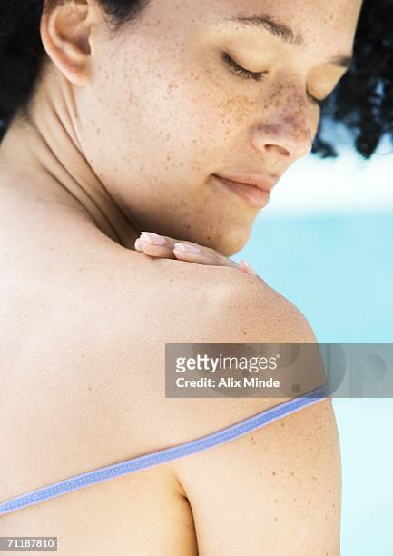 young woman touching shoulder - looking over shoulder stockfoto's en -beelden