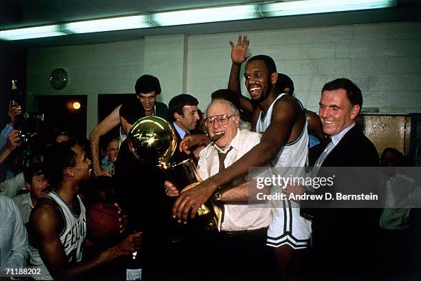 Boston Celtics General Manager Red Auerbach celebrates with the NBA championship trophy after the Celtics defeated the Los Angeles Lakers in Game 7...