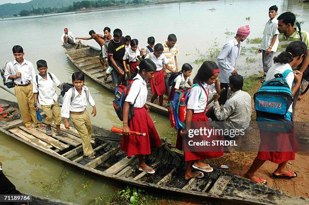 In this photograph dated 04 June 2006 villagers travel by boat at the flood affected area at Rajabari village, 25km from Guwahati, the capital city...