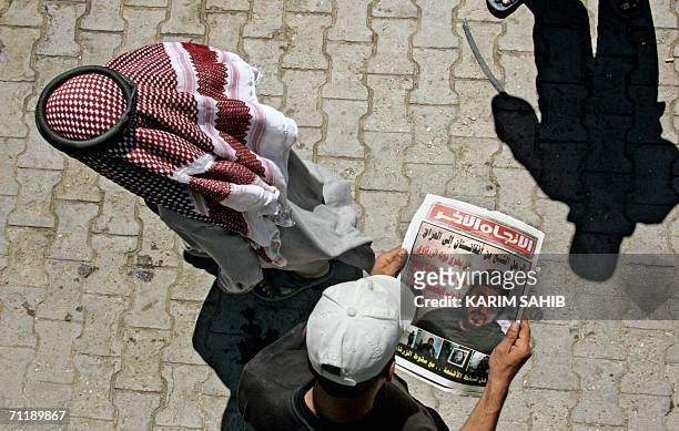 An Iraqi youth looks at the image of slain al-Qaeda leader in Iraq Abu Musab al-Zarqawi published 13 June 2006 in an Iraqi newspaper in Baghdad....