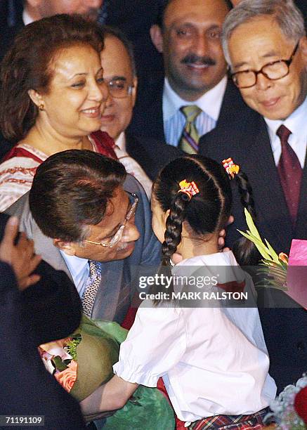 Pakistani President Pervez Musharraf and his wife Begum Sehba Musharraf greet a young Chinese girl as they arrive at the Pudong Airport for the...