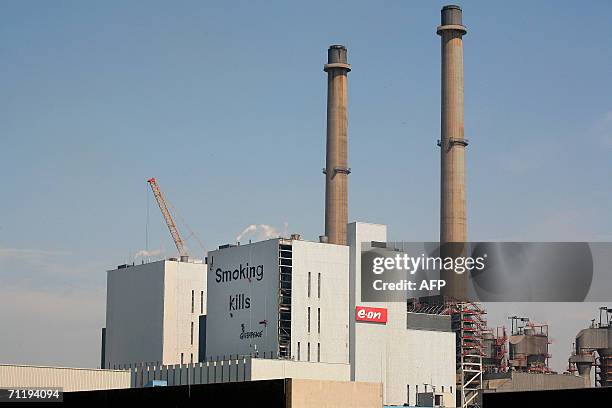 Rotterdam, NETHERLANDS: Members of Greenpeace rapel down the side of new coal power-station Eon 13 June 2006 in Rotterdam, where they are in the...