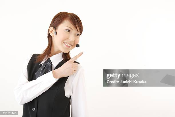 a  woman with headset pointing a direction - light skin black woman stockfoto's en -beelden