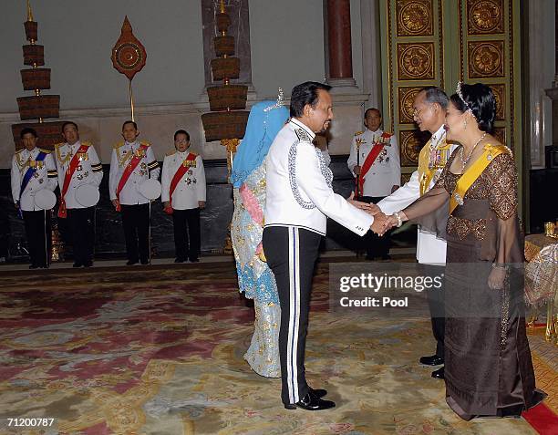 Thailand's King Bhumibol Adulyadej and Queen Sirikit greet the Sultan of Brunei as they attend the Royal banquet at the Golden Palace on June 13,...