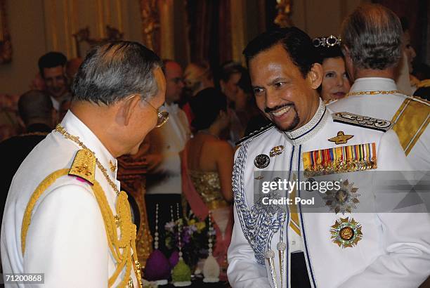 Thailand's King Bhumibol Adulyadej speaks with Sultan of Brunei as they attend the Royal banquet at the Golden Palace on June 13, 2006 in Bangkok,...