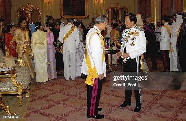 Thailand's King Bhumibol Adulyadej speaks with the Sultan of Brunei as they attend the Royal banquet at the Golden Palace on June 13, 2006 in...