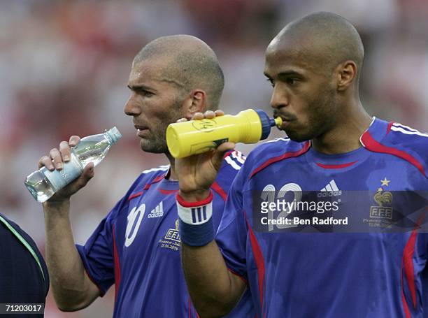 Dejected pairing of Thierry Henry and Zinedine Zidane of France take a drink, following their team's 0-0 draw with Switzerland during the FIFA World...