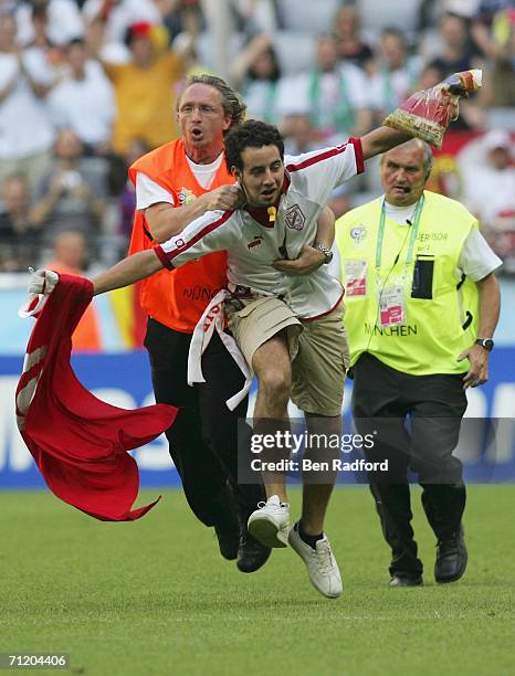 Tunisian fan is tackled by a steward, after invading the pitch during the FIFA World Cup Germany 2006 Group H match between Tunisia and Saudi Arabia...