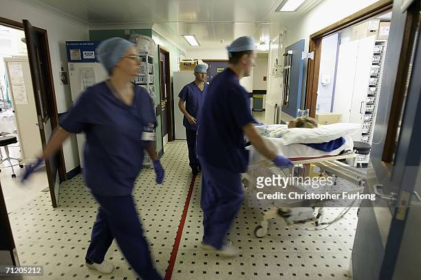 Theatre staff at The Queen Elizabeth Hospital Birmingham take a patient into recovery after an operation on June 14, 2006 in Birmingham, England....