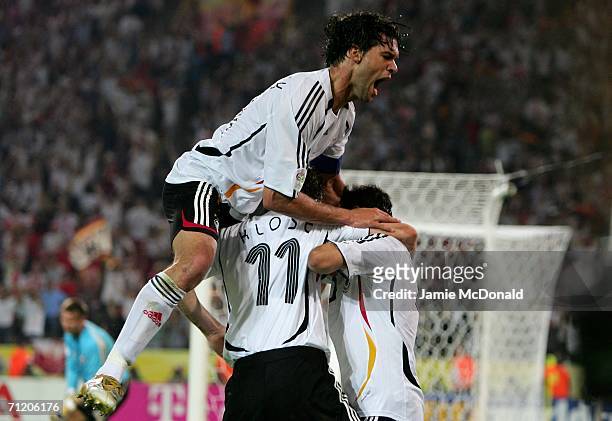 Michael Ballack and Miroslav Klose of Germany congratulate Oliver Neuville of Germany for scoring the winning goal during the FIFA World Cup Germany...